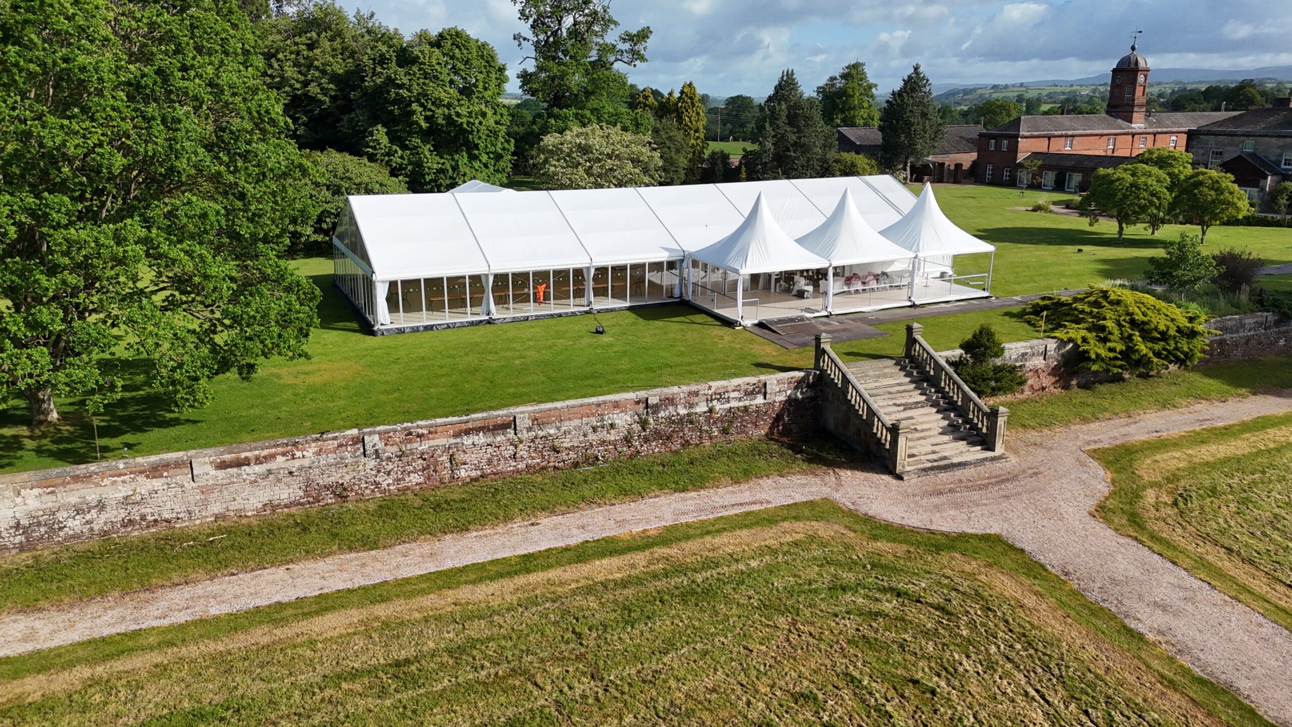 Aerial view of an illuminated wedding marquee at dusk